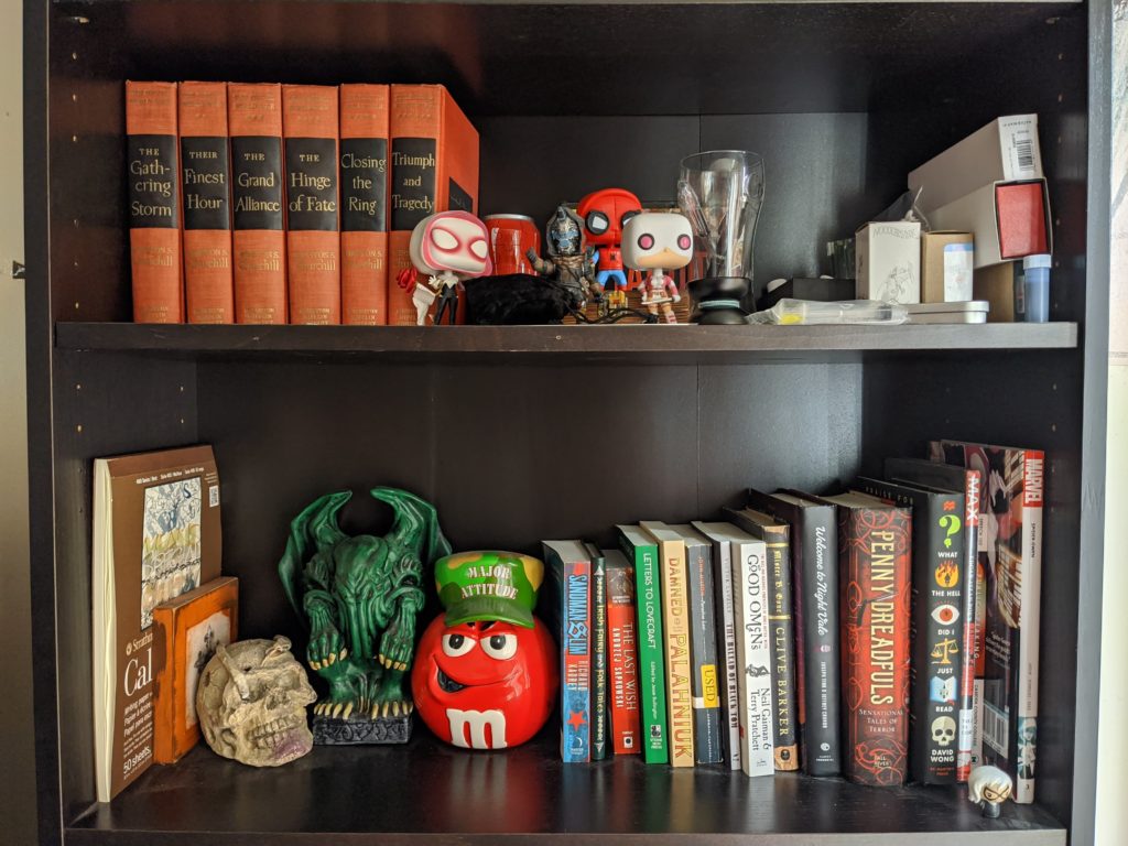 Book shelf with books and trinkets such as bobble-heads